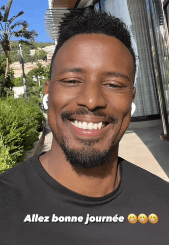 a man with a beard is smiling with the words allez bonne journee above him