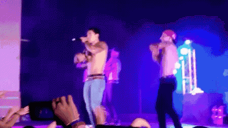 a man without a shirt is singing into a microphone