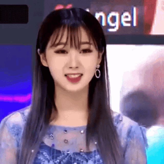 a close up of a woman with long hair and bangs smiling .