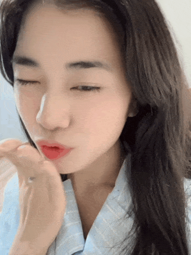 a close up of a woman with her eyes closed and red lipstick on her lips