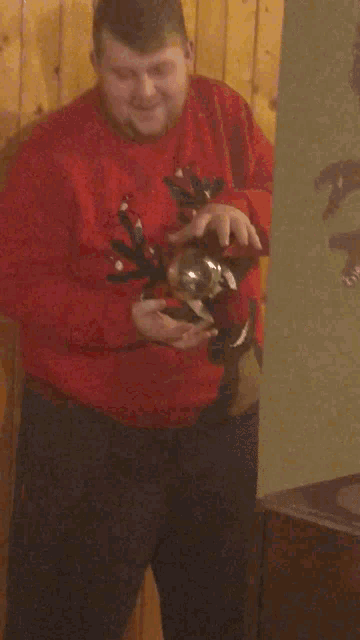 a man in a red sweater with antlers on it