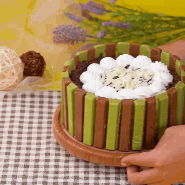 a person is holding a cake that is made out of kitkat bars