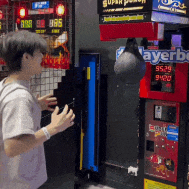 a man stands in front of a machine that says super punch on it