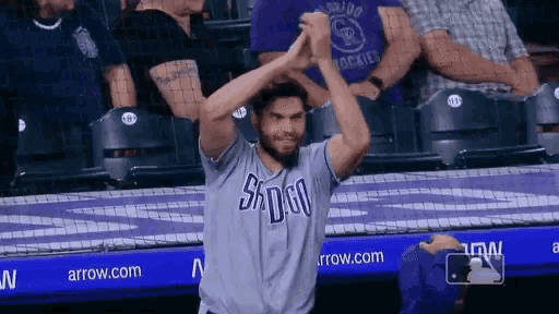 a man wearing a san diego jersey is clapping