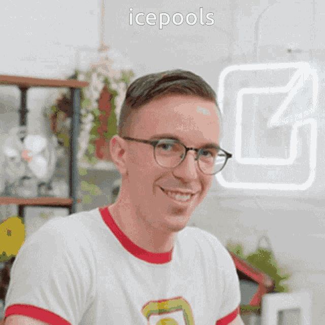 a man wearing glasses and a white shirt is smiling in front of a sign that says icepools