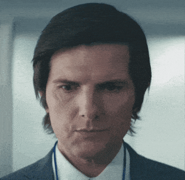 a close up of a man 's face with a blue lanyard around his neck