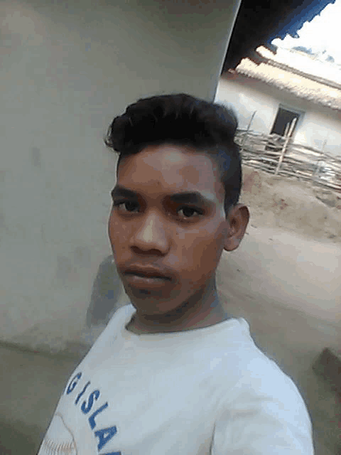 a young man taking a selfie wearing a shirt that says gisla