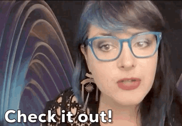 a woman with blue hair and glasses has the words check it out below her