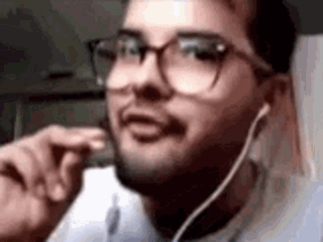a man wearing glasses and headphones is making a face .
