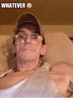 a man wearing glasses and a hat is sitting on a couch with the word whatever above him