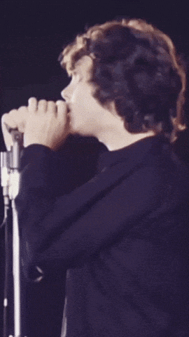 a person singing into a microphone with a black shirt on