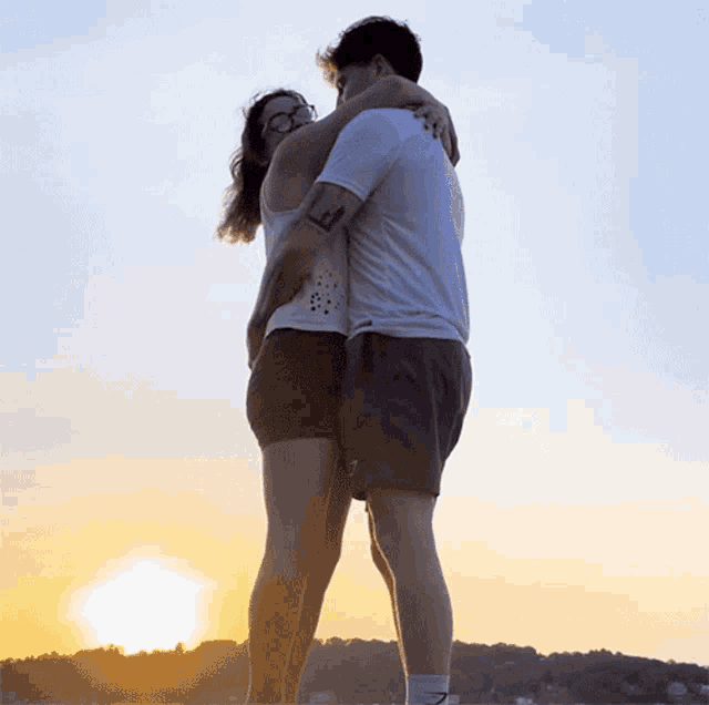 a man holds a woman in his arms with a tattoo on his arm that says lm