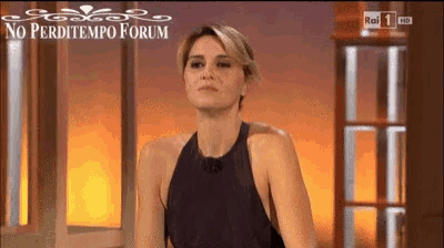 a woman in a black dress is sitting in front of a window with the words no perditempo forum on the bottom