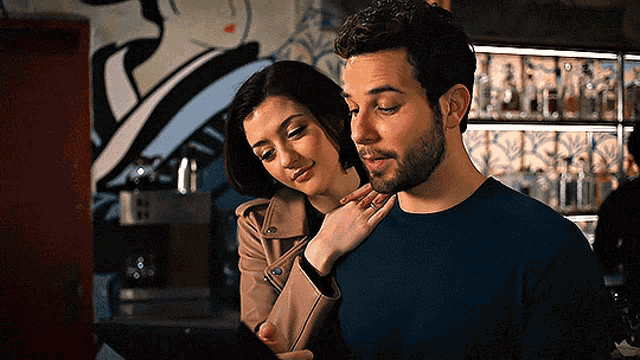 a man and woman are looking at a tablet together .