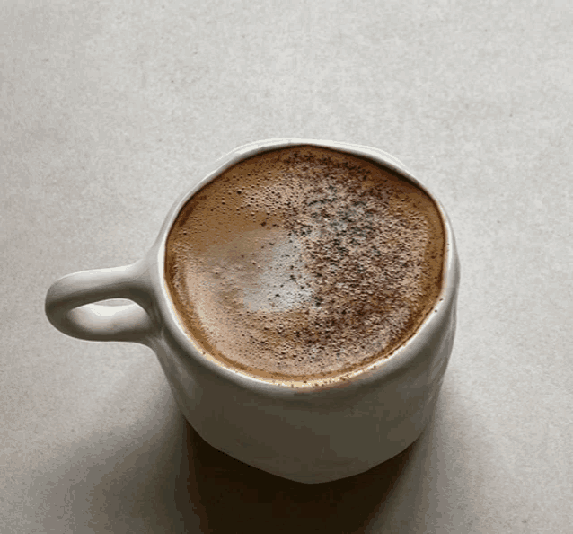 a close up of a cup of coffee with foam