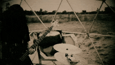 a black and white photo of a person playing a guitar