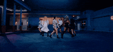 a group of young women are dancing in front of a sign that says ticket
