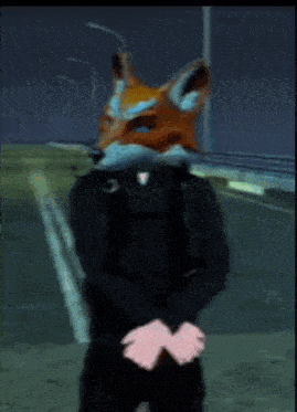 a man wearing a fox mask is standing on a street