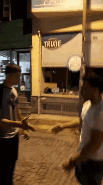 people walking in front of a store that says trixie