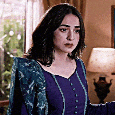 a woman in a purple dress with blue buttons on the front