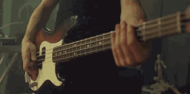 a close up of a person playing a bass guitar
