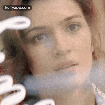 a close up of a woman 's face behind a glass window .