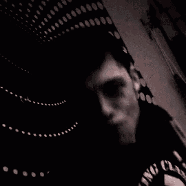 a man is taking a selfie in a room with guitars .