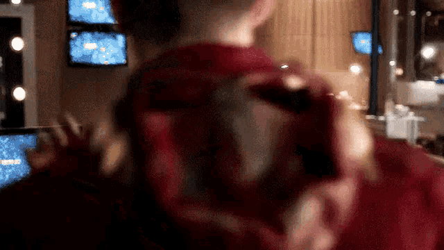 a man in a red shirt is taking a picture of himself with a camera