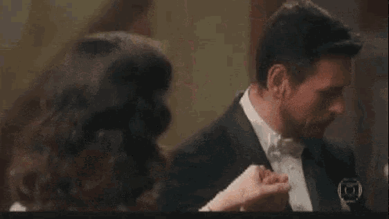 a man in a tuxedo is dancing with a woman in a white dress