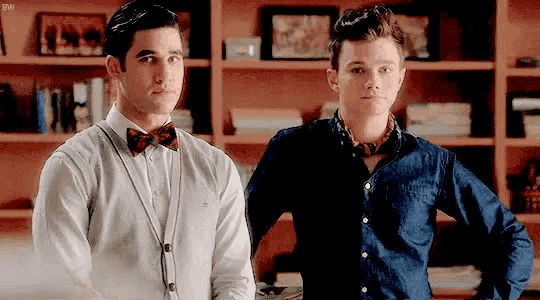 two men in bow ties are standing next to each other in a room .