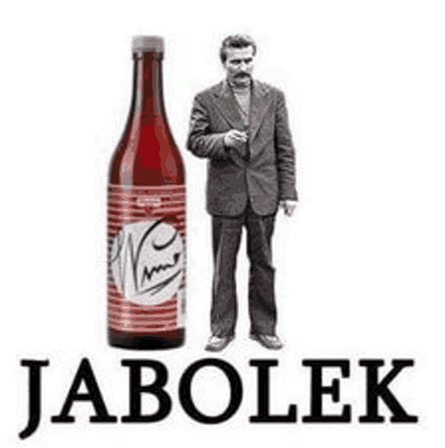 a man in a suit is standing next to a bottle of jabolek beer .