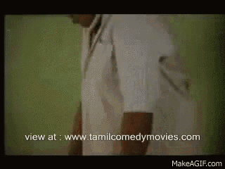 a man in a white shirt is standing in front of a green wall with the website www.tamilcomedymovies.com in the corner