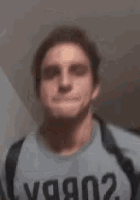 a man wearing a blue shirt with the word y written on it is making a funny face .