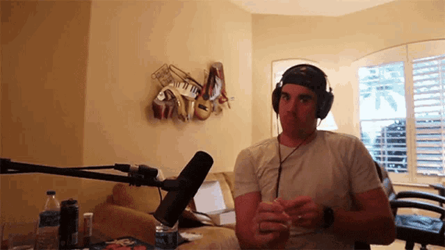 a man wearing headphones is standing in front of a microphone
