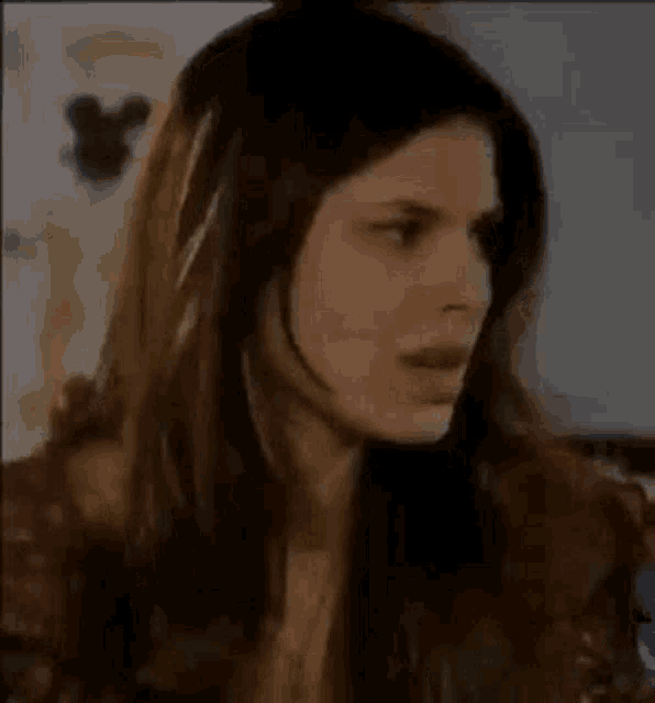 a woman with long hair is making a funny face while sitting on a couch .