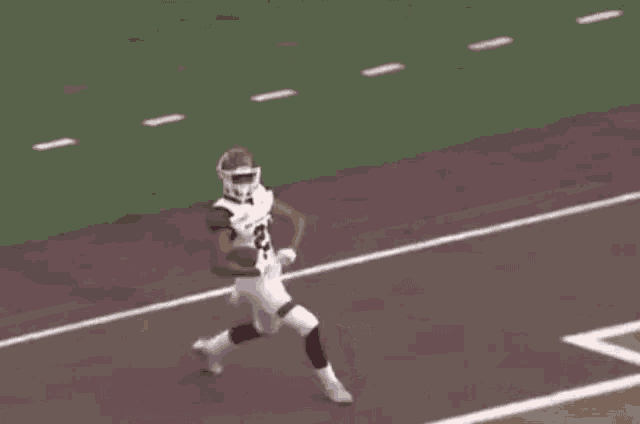 a football player with the number 21 on his jersey stands on the field