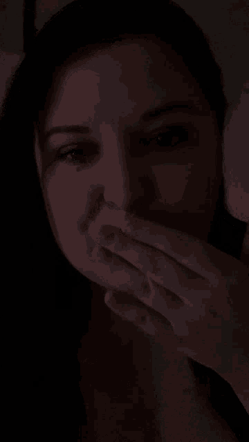 a close up of a woman 's face with a dark background