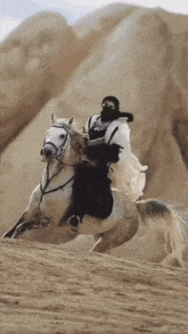 a man is riding a horse in the desert