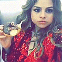 a woman in a red jacket is holding a donut .
