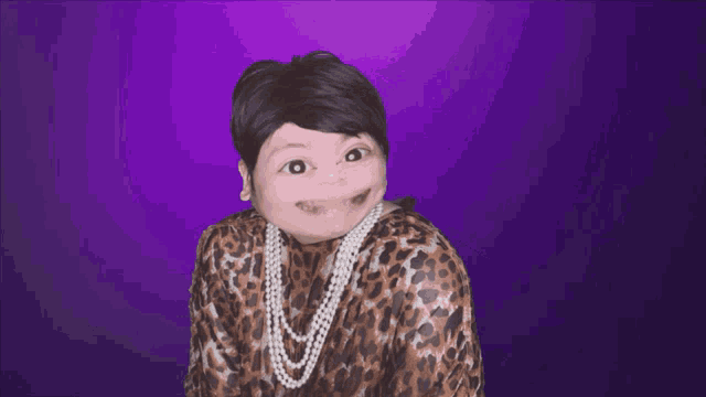 a woman wearing a leopard print shirt and pearls smiles