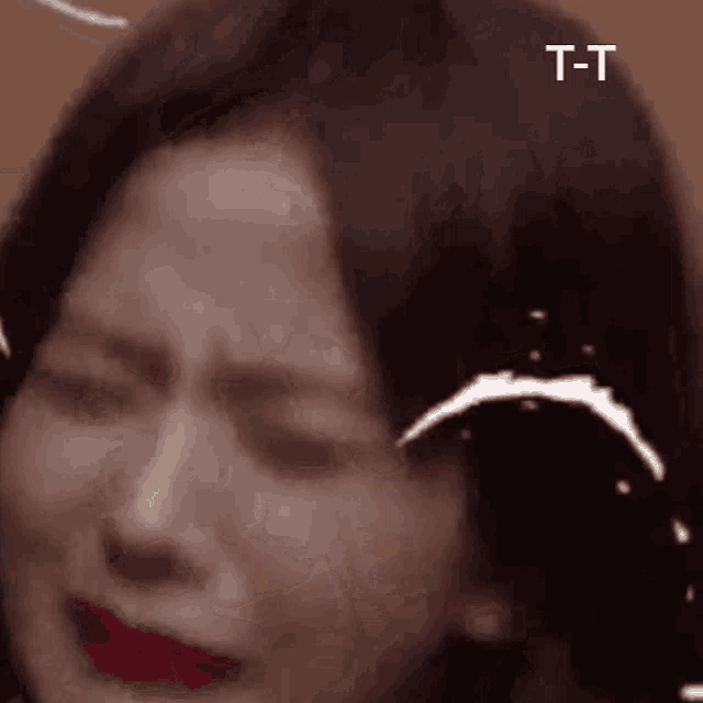 a close up of a woman 's face with her eyes closed and a t-t sticker on it .