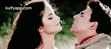 a man and a woman are kissing each other with their eyes closed .