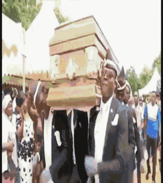 a man in a suit is carrying a coffin in a crowd of people