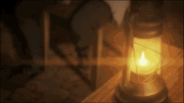 a lantern sits on a wooden table with a candle in it