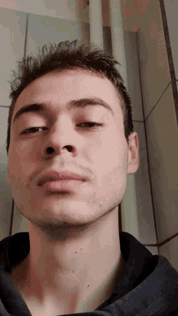 a close up of a man 's face with a black shirt on