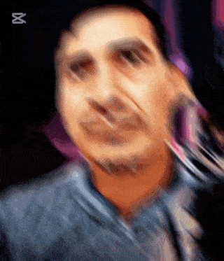 a blurry picture of a man 's face with the letter x on the bottom right
