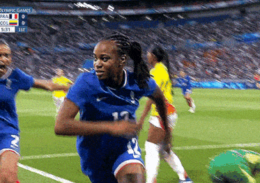 a woman in a blue jersey with the number 12 on it is playing soccer