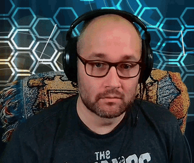 a bald man wearing headphones and a shirt that says the