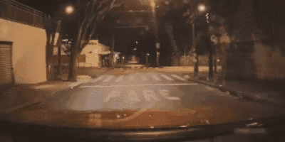 a car is driving down a street at night with a blurred background .