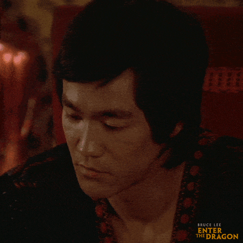 a close up of bruce lee 's face with the words enter the dragon on the bottom